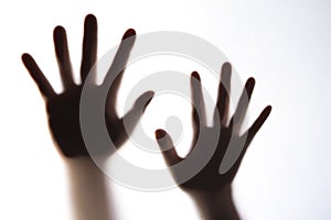 The silhouette of a woman`s hand expressing fear.