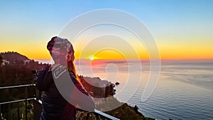 Silhouette of woman with scenic view on sunrise at Mediterranean Ionian sea seen from the main square (Piazza IX Aprile) Taormina