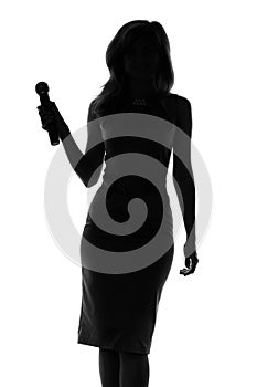 Silhouette of a woman singing with a microphone in hands