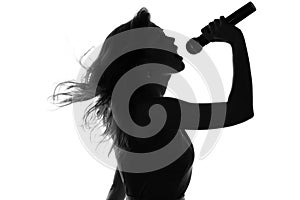 Silhouette of a woman singing with a microphone in hands