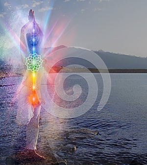 Silhouette of woman sits in a otus pose on beach sunset view, glowing seven all chakra. Kundalini energy. girl practicing yoga