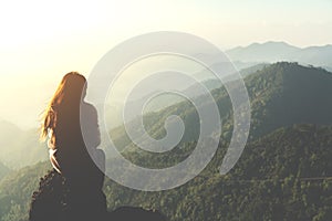 Silhouette woman sitting on mountain in morning and vintage filt