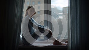 Silhouette of a woman sitting near the window