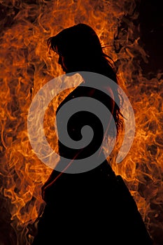 Silhouette woman stand in front of fire