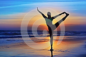 Silhouette of woman stretching at yoga retreat on sunset beach