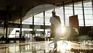 Silhouette of woman stucked at airport terminal over flight cancellation,calling family, sitting in almost empty airport