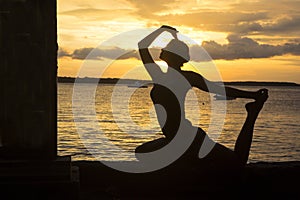 Silhouette of a woman at sunset over Bali sea