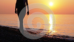 Silhouette of a Woman at Sunset Running along the Seashore