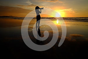 Silhouette woman take picture on sunset background