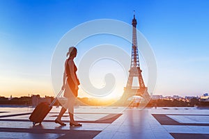 Silhouette of woman tourist with suitcase near Eiffel Tower, Paris