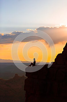 Silhouette of a woman on the trail at Cathedral Rock at sunset in Sedona. The colorful sunset over Sedona's