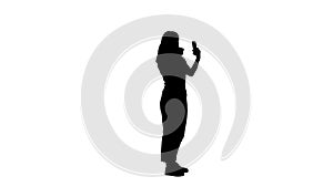 Silhouette Woman using lipstick and looking in her phone.