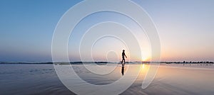 silhouette of a woman walking along the seashore. Spiritual Peace Meditation. A happy girl walks along the seashore against the