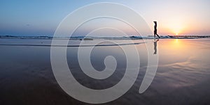 silhouette of a woman walking along the seashore. Spiritual Peace Meditation. A happy girl walks along the seashore against the