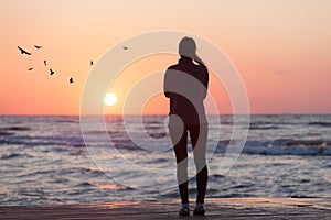 Silhouette of woman watching sunrise