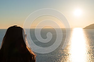 Silhouette of woman is watching sunset over the sea