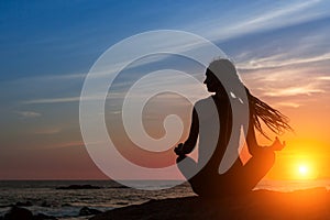 Silhouette woman yoga on the beach at amazing sunset. Meditation.