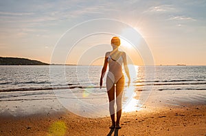 Silhouette woman yoga on the beach at sunrise. Woman is practicing yoga at sunset on sea shore