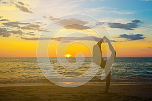 Silhouette woman with yoga posture on the sea beach