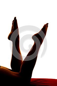 Silhouette of womans legs kicked up toes pointed