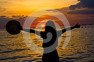 Silhouette women enjoying a beautiful sunset on the beach.