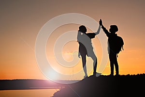 Silhouette women and girl backpacker on the top mountain