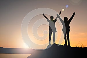 Silhouette women and girl backpacker on the top mountain