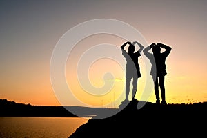 Silhouette women and girl backpacker on the top mountain