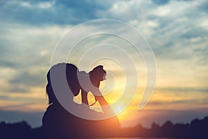 Silhouette women Nature photographer with digital camera on the mountain and lake