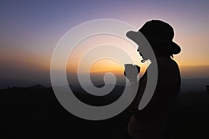 Silhouette of a women is praying to God on the mountain. Praying hands with faith in religion and belief in God on blessing