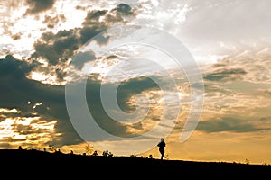 Silhouette women`s runners run on hillsides at sunset. jogging workout wellness concept
