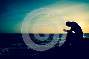 Silhouette women sitting alone on the rock. Mental health,