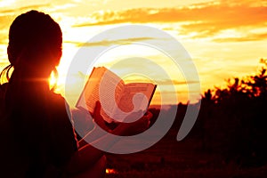 Silhouette women sitting read a book on holiday. photo