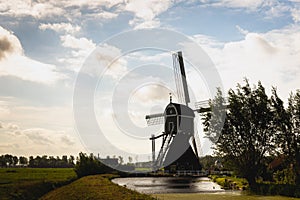 Silhouette of a wooden hollow post mill in a Dutch polder