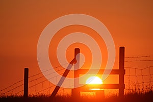 Silhouette of wooden stile at sunset