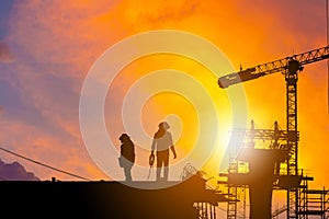 Silhouette of Worker on building construction site at sunset in evening time