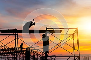 Silhouette of worker on building site, construction site at sunset in evening time