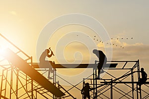 Silhouette of worker on building site, construction site at sunset in evening time