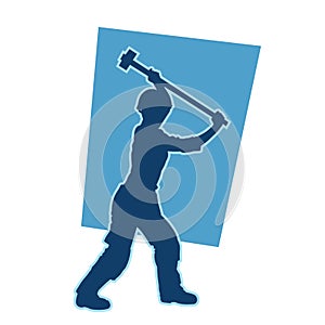silhouette of a worker swinging his sledge hammer.