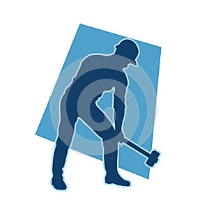 silhouette of a worker swinging his sledge hammer.