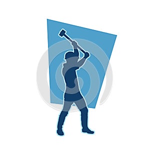silhouette of a worker swinging his sledge hammer.
