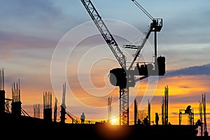 Silhouette of worker team on building site, construction site at sunset in evening time