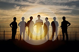 Silhouette of worker team at building site during sunset photo