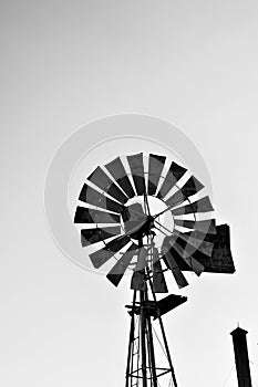 Silhouette of a working vintage country Windmill in sunset light or twilight.