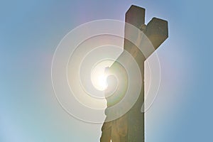 Silhouette of Jesus Christ on the worship cross with sun on background