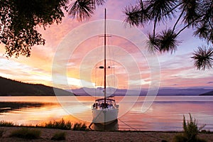 Silhouette of a yacht with a lowered ladder on Lake Baikal at dawn.