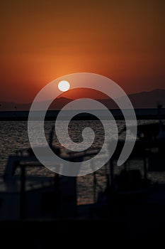 Silhouette of yachts at sunset in the harbor. Sunset over the sea. Fishing boats in the port. Boats in the bay at sunset