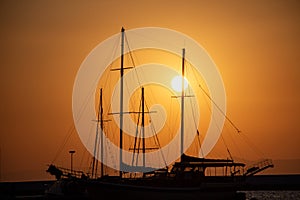 Silhouette of yachts at sunset in the harbor. Silhouette of a sailboat at sunset in the sea