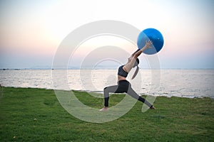 Silhouette yoga ball yong woman in the beach