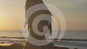 Silhouette yoga practice at sunset. Yong woman doing yoga exercise on the beach